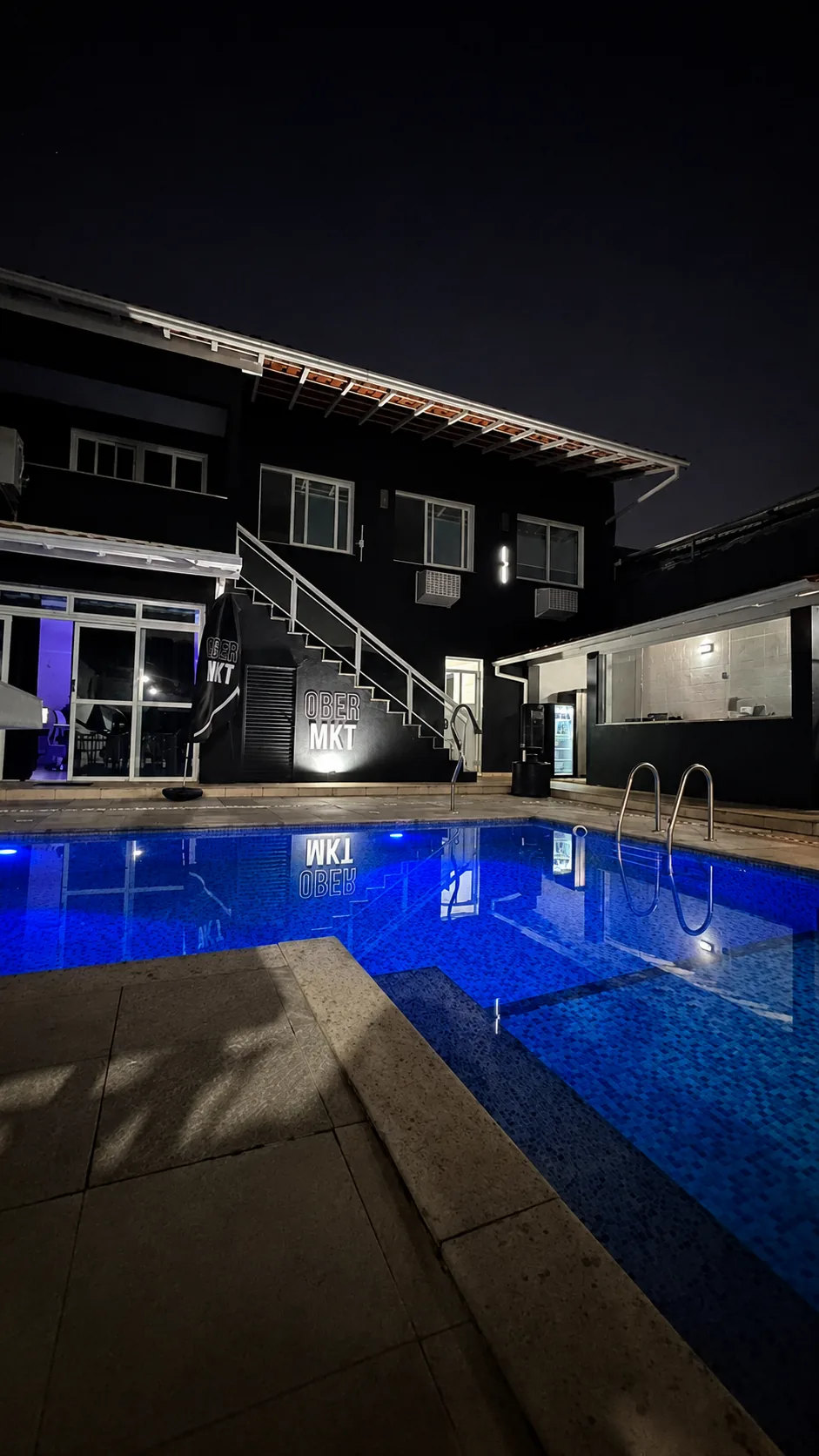 Mansão Ober MKT com piscina iluminada à noite